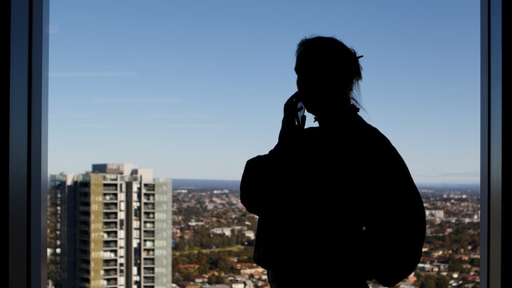 Silhouette of woman talking on phone with Parramatta CBD in the background