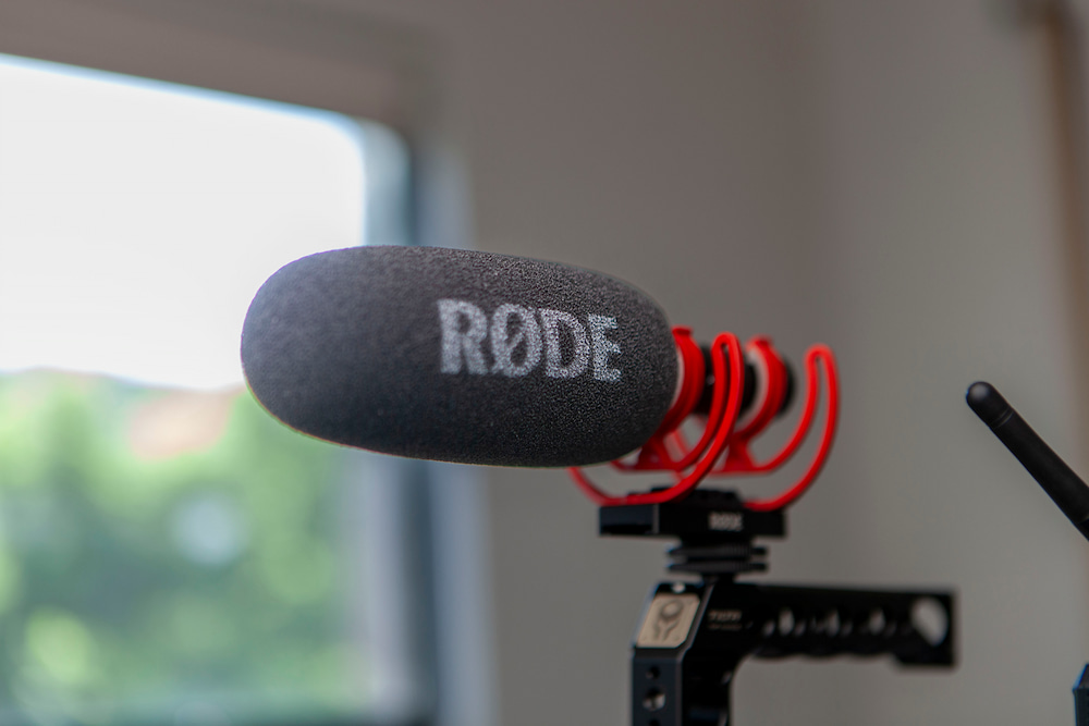 A close-up of a røde directional microphone with a fuzzy windscreen, mounted on audio equipment, for enhanced sound recording in a professional setting, used for hire as part of the Signal Box Studio.